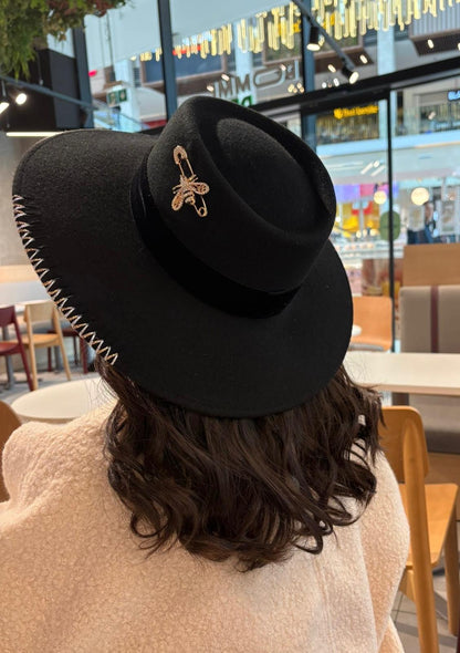 Chapeau à grand bord noir avec broche abeille dorée, Tess Atelier